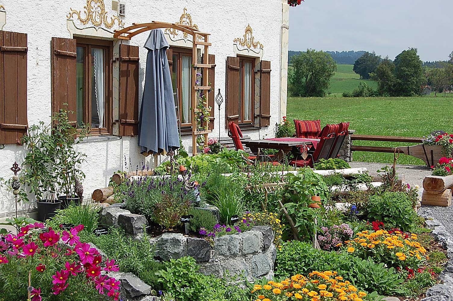 Blumengarten und Sitzplatz am Haus